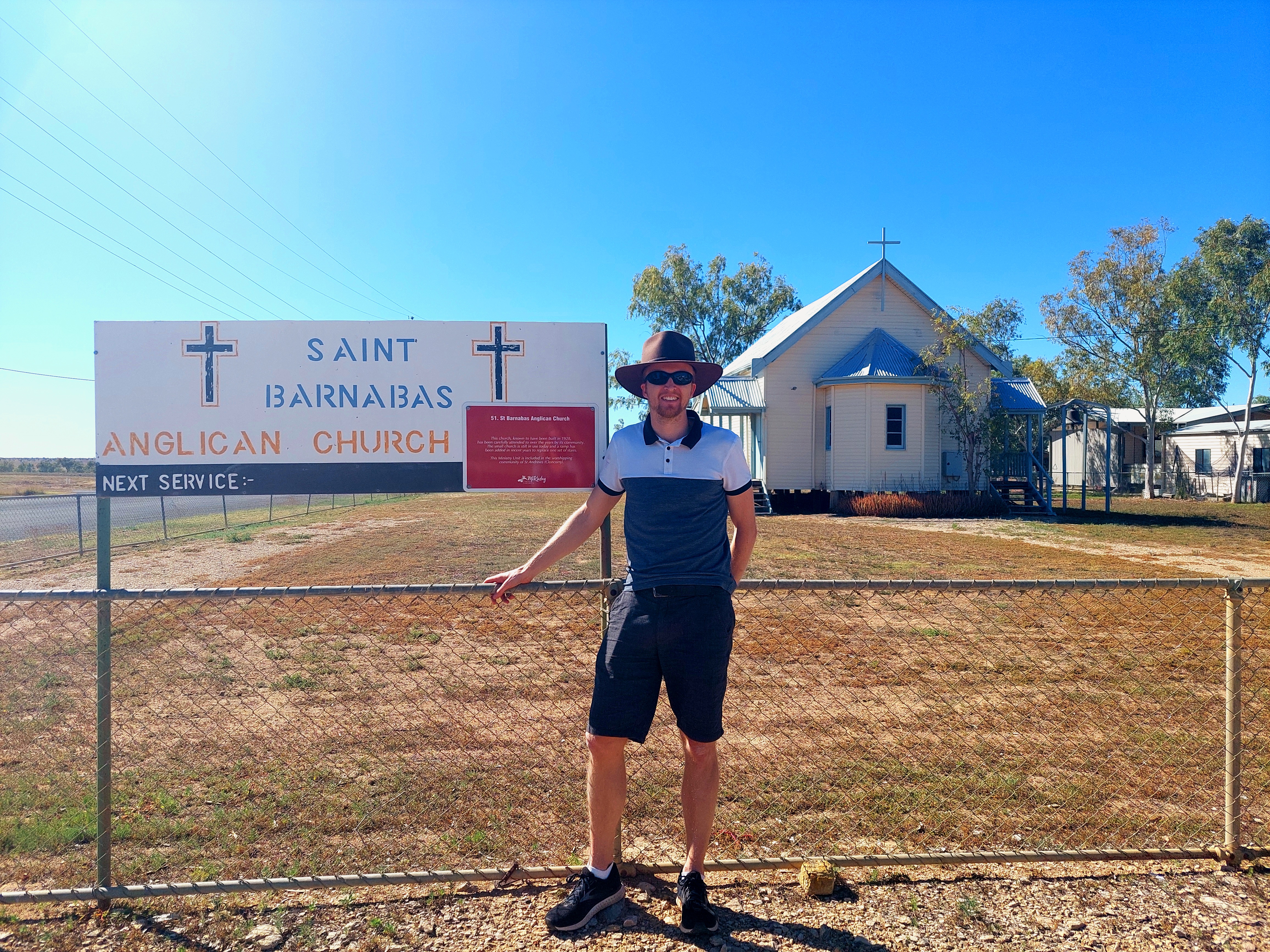 Simon Owen leans against the fence in front of St Barnabas Julia Creek